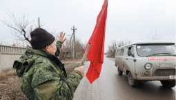 Житель Донецка приветствует военных красным флагом