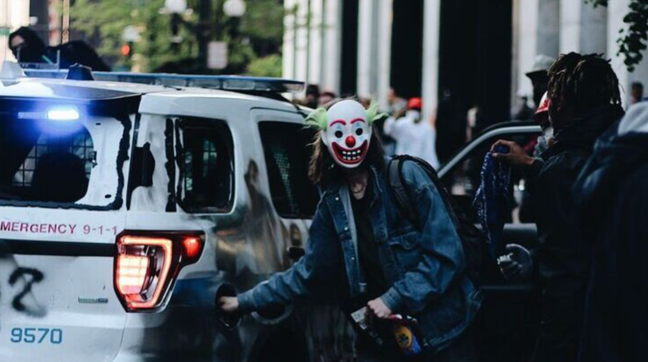 Клоун бандит. Темный рыцарь Джокер в полицейской машине. Джокер в полицейской машине.